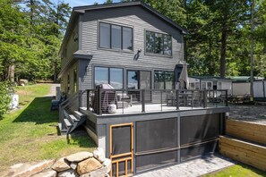 Una casa a due piani con un balcone, ampie finestre e un garage.