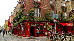 Un bâtiment en briques rouges orné de nombreuses enseignes indiquant « The Temple Bar » et « Cloud Nine ».