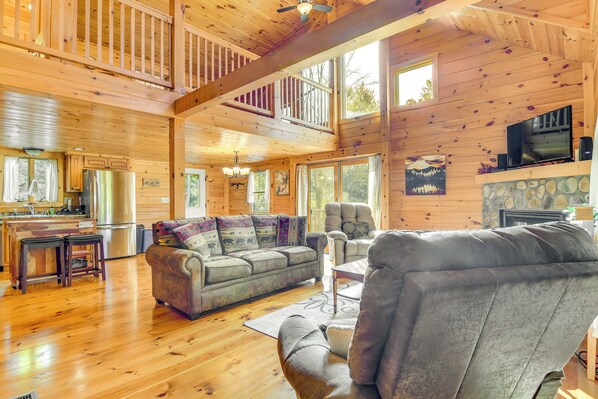L’intérieur d’un chalet en bois comprend un salon, une cuisine et un balcon.