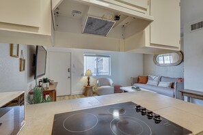 Une cuisine moderne dotée d’un îlot central, d’un coin repas avec un canapé et d’une fenêtre laissant entrer la lumière naturelle.