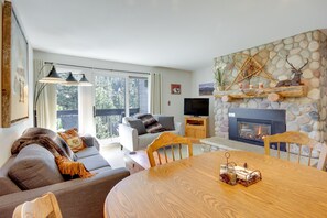Ein gemütliches Wohnzimmer mit Kamin, Esstisch und Sofa.