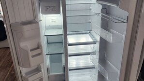 An open refrigerator with multiple shelves and a control panel. - Buddy Ebson w/EV charger II (North Fort Myers)