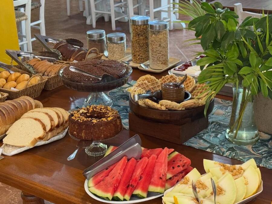 Una mesa de buffet con diferentes alimentos, como pan, pasteles y frutas.