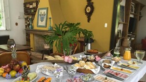 A breakfast buffet with various food items and a clock on the wall. - Pousada Villa Agrifóglio (Imbituba)
