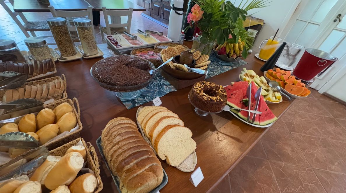 A buffet with various food items including bread, pastries, and fruits.