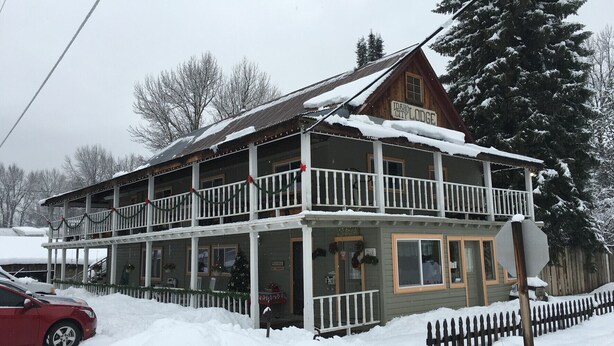 A two-story lodge with a balcony, surrounded by snow. - The Idaho City Hotel (Idaho City)