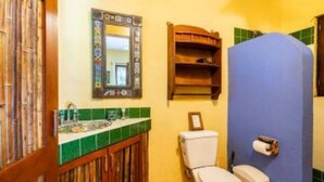 Un baño con inodoro, lavamanos y espejo.
