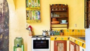 Una cocina con estufa, horno, repisas con vajilla y un letrero de Pepsi.