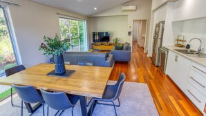 A modern kitchen with white cabinets, a stainless steel refrigerator, and a built-in oven. - Kiali @ Cape Villas Dunsborough (Dunsborough)