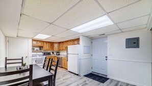 Una cocina moderna con armarios de madera, un refrigerador blanco y un microondas.
