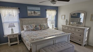 A bedroom with a bed, nightstands, a dresser, a bench, a ceiling fan, and a large mirror. - WW Condo 1.5 blks to beach and boardwalk. Walk to shops, restaurants and CC. (Wildwood)