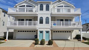 A two-story residential building with a central entrance, a garage, and a balcony on each floor. - WW Condo 1.5 blks to beach and boardwalk. Walk to shops, restaurants and CC. (Wildwood)