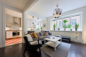 A modern living room with a sofa, coffee table, and a view of the kitchen. - Vibrant neighbourhood in the heart of popular Södermalm. Safe and central street (Stockholms län)