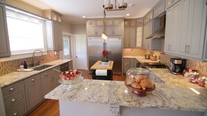 Una cocina moderna con encimeras de granito, electrodomésticos de acero inoxidable y armarios en color gris claro.