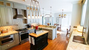 Una cocina moderna con encimeras de granito, electrodomésticos de acero inoxidable y una isla central.