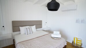 A neatly arranged bedroom with a bed, bedside table, and a hanging light fixture. - Villa Picuas R in Rio Grande Magical place (Río Grande)
