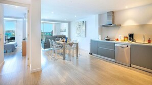 A modern apartment with a kitchen, dining area, and living room.