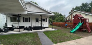 Enjoy a relaxing evening on the covered porch with outdoor seating and a backyard play area featuring a fun slide.