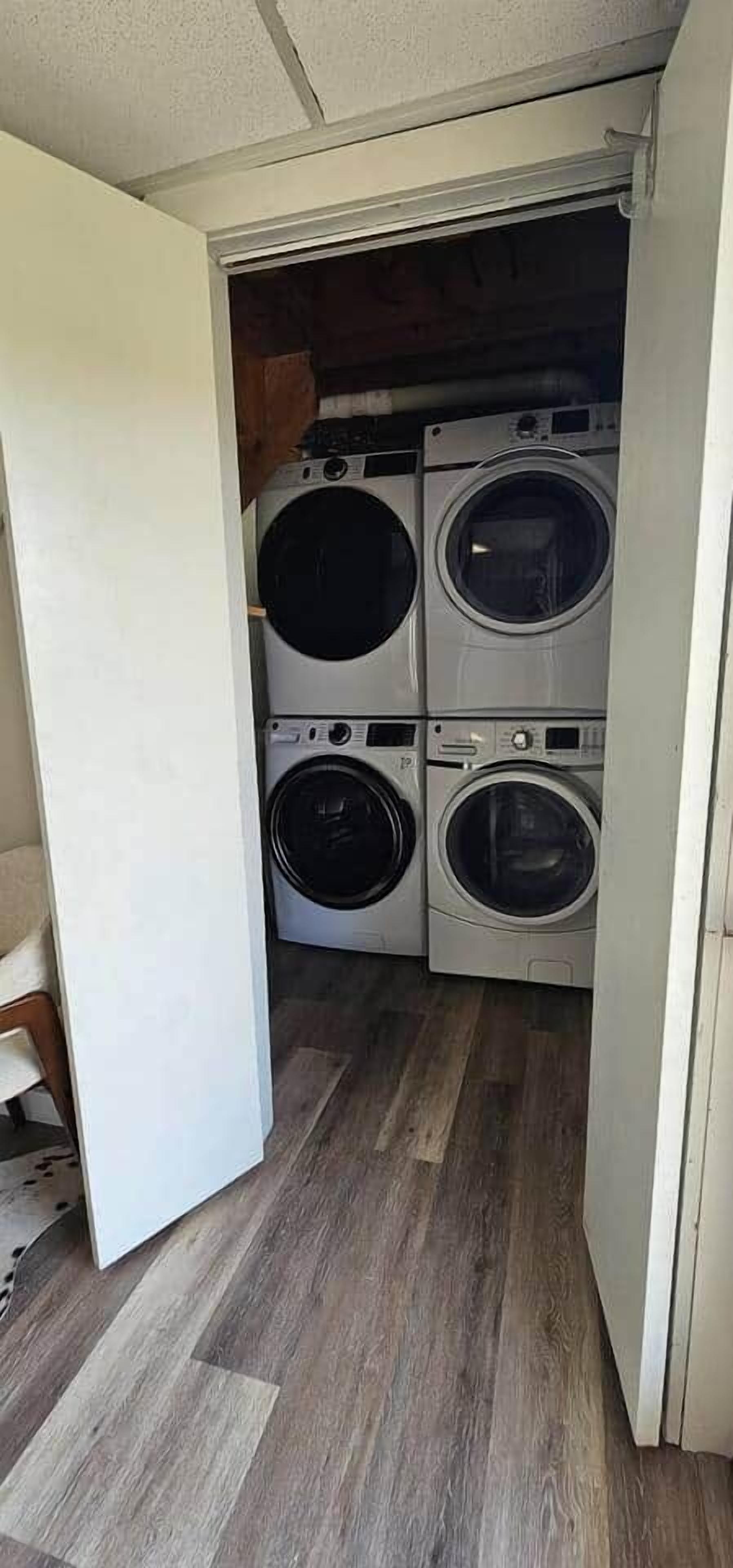 Un lavadero con cuatro lavadoras apiladas.