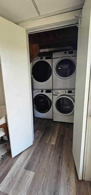 A laundry room with four stacked front-loading washing machines.