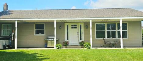 A single-story house with a covered porch, a front door, and a small front yard.