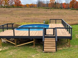 Una piscina con cubierta de madera y barandillas de metal.