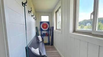 A corridor with a target board, a blue barrel, and a metal bowl.