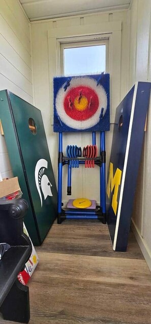 A narrow hallway with a door at the end, flanked by two large doors with logos.