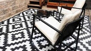 A patio with outdoor furniture, a wooden staircase, and a wall-mounted planter. - Cozy Tiny studio 20Min to DwTn SF & 7min to SFO (South San Francisco)