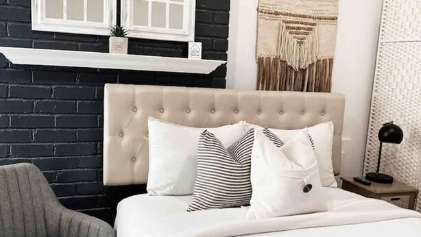 A bed with a tufted headboard, white bedding, and striped pillows. - Cozy Tiny studio 20Min to DwTn SF & 7min to SFO (South San Francisco)