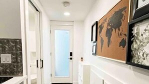 A narrow hallway with a wooden floor, white walls, and a door at the end. - Cozy Tiny studio 20Min to DwTn SF & 7min to SFO (South San Francisco)