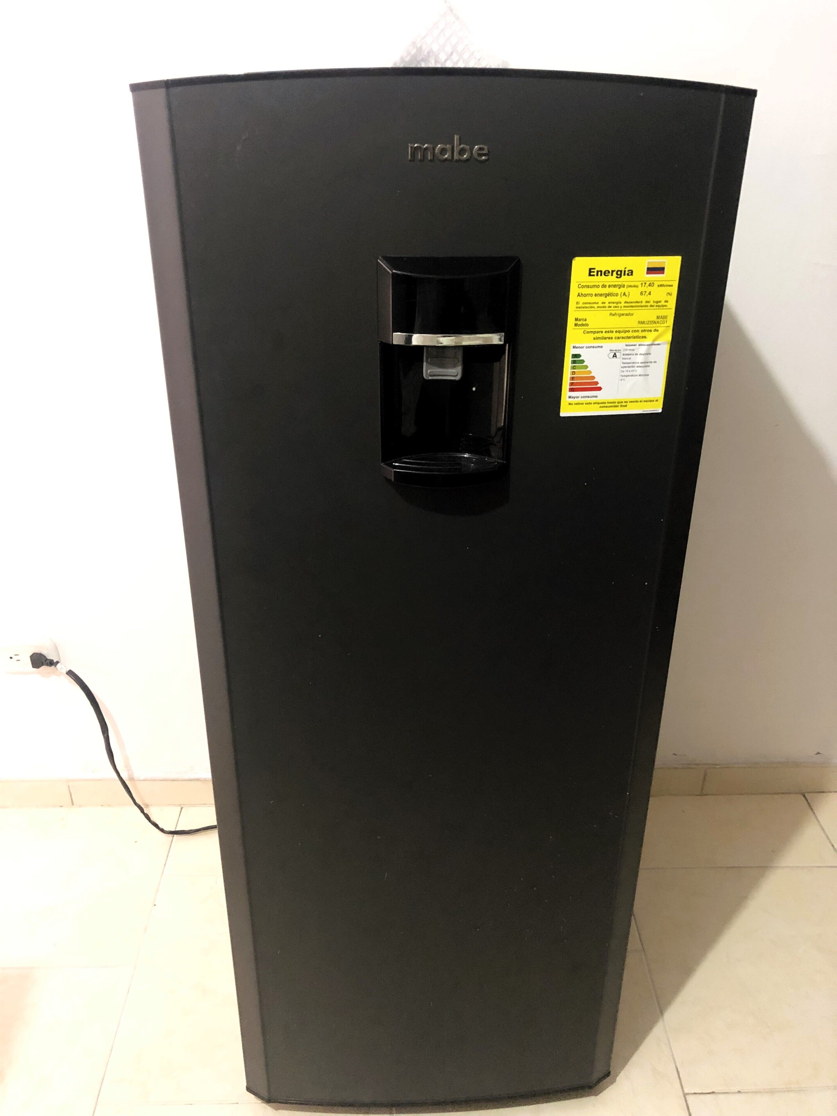 Frigorifero nero dotato di dispenser per acqua e adesivo che indica il consumo energetico.