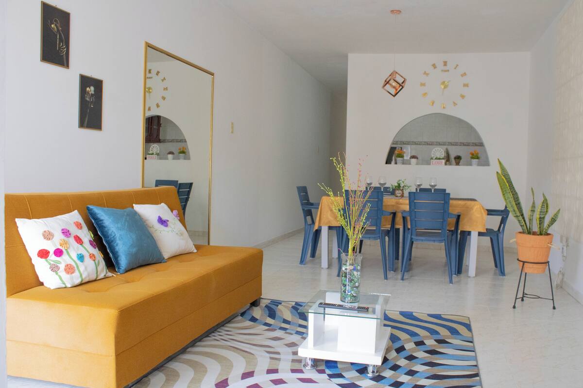 Un salon comprenant un canapé, une table basse et un coin repas avec des chaises et une table.