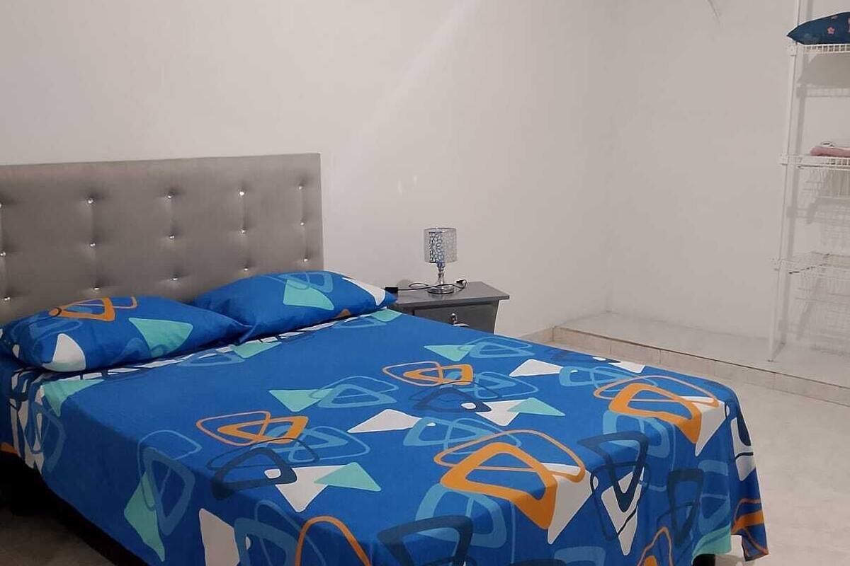 Une chambre à coucher comprenant un lit, une table de chevet et une étagère.