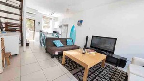 A modern living room with a sofa, coffee table, and a flat-screen TV. - Enjoy beachside vibes at beautiful Henley Beach! (Henley Beach)