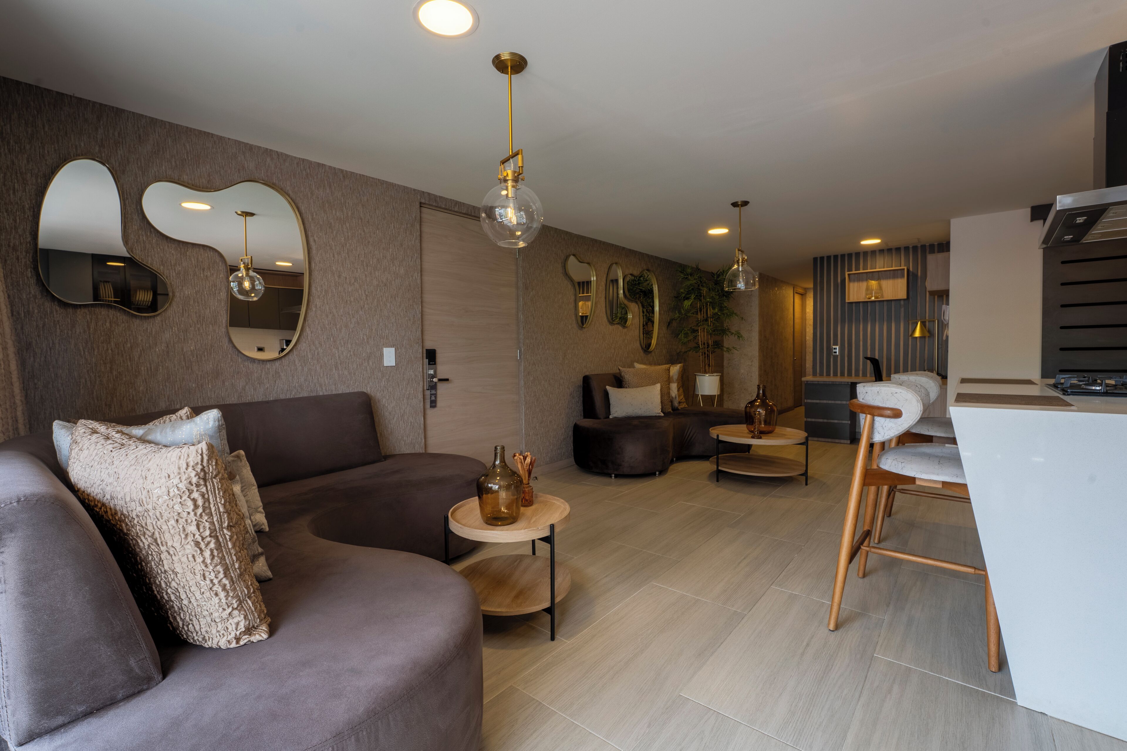 A modern living room with a sofa, a coffee table, and a dining area with a chair and a small table.