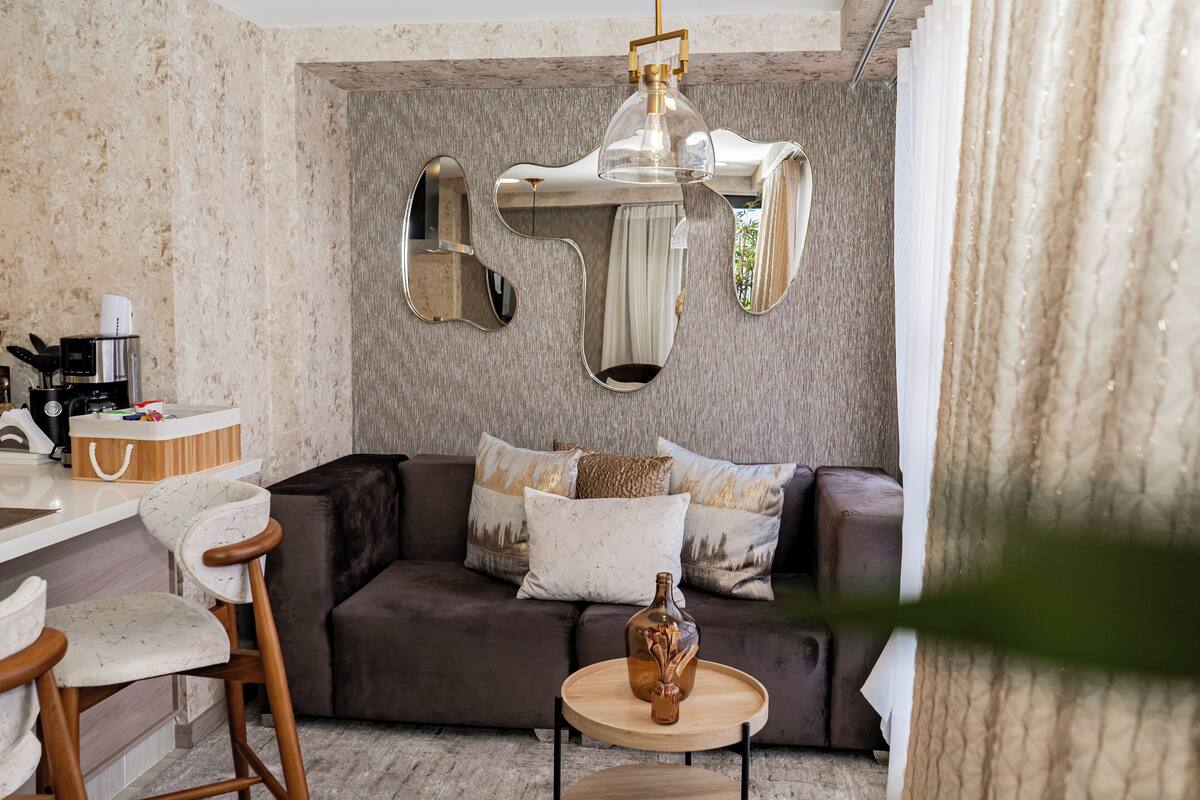 Una sala de estar moderna con un sofá, una cafetera y un jarrón decorativo sobre una mesita.
