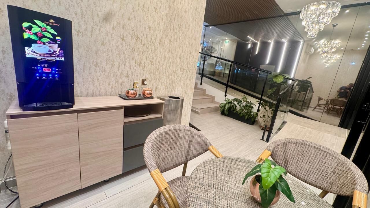 Ein modernes Interieur mit einem Holzkabinett, einem Fernseher, Korbstühlen und einer Treppe, die zu einer oberen Ebene führt.