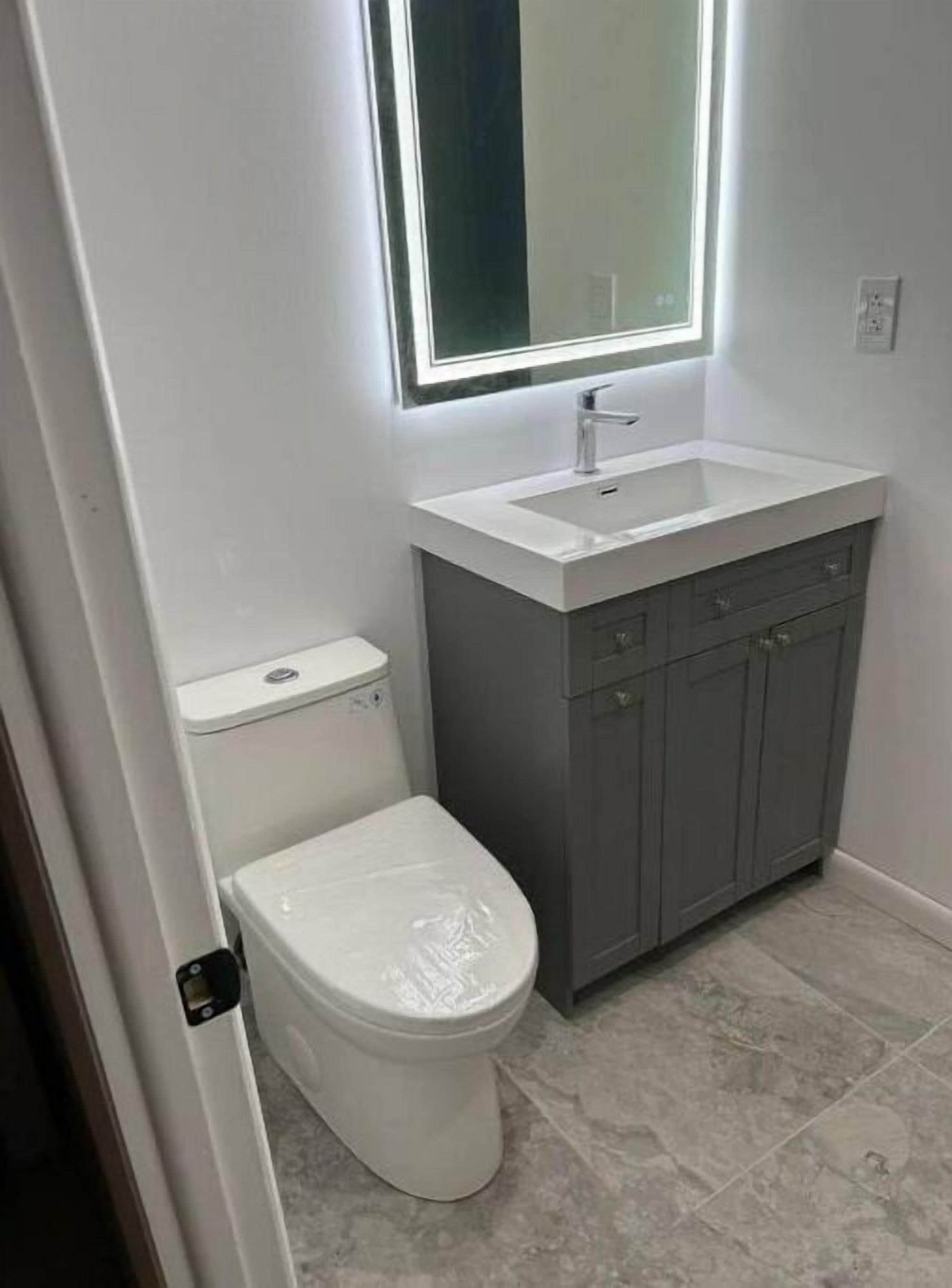 Un baño con inodoro, lavabo y espejo.