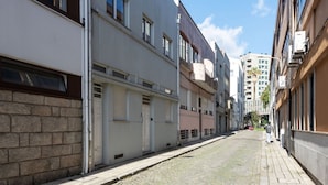 En smal gade med bygninger på begge sider, der viser en blanding af moderne og traditionel arkitektur.