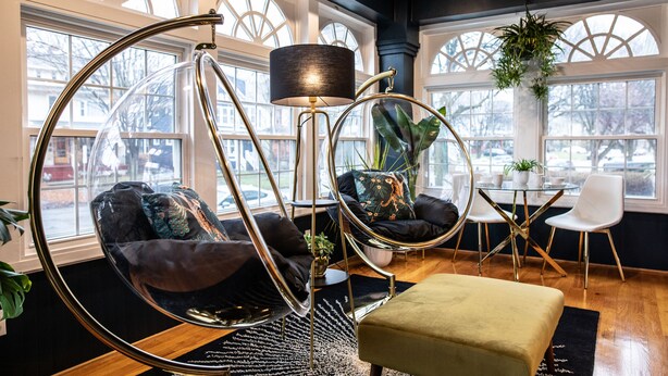 A modern interior with a hanging chair, a round table, and a sofa. - Spacious! Game Room, near Restaurants, Bars, Shops, DT BFLO & Niagara Falls! (Buffalo)