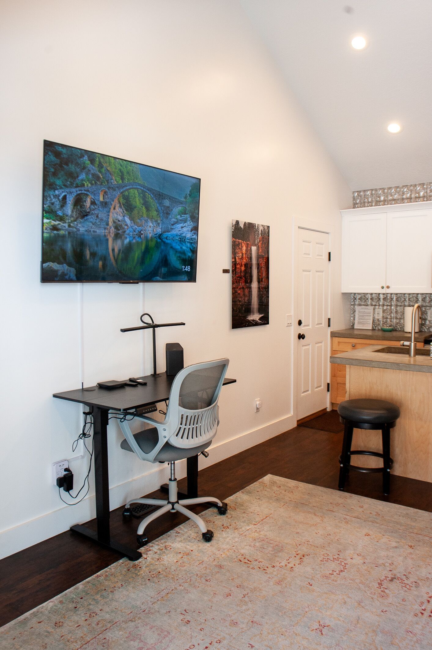 Ein Arbeitszimmer mit Schreibtisch, Stuhl und Bildern an der Wand.