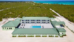 A resort with a pool, multiple guest rooms, and a view of the ocean.