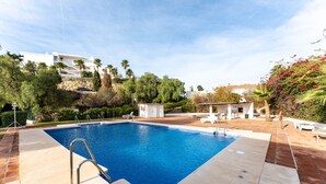 A rectangular swimming pool with a metal ladder, surrounded by a tiled deck. There are lounge chairs and a barbecue area in the background. - MalagaSuite Blue Paradise House (Benalmádena)