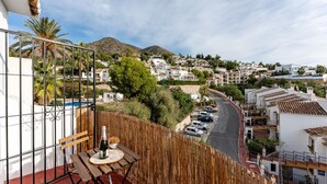 A residential area with white buildings, a street, and a mountain in the background. - MalagaSuite Blue Paradise House (Benalmádena)