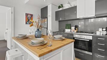 A modern kitchen with a central island, stainless steel appliances, and white cabinetry.