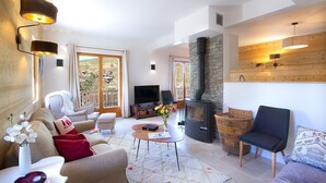A modern living room with a fireplace, comfortable seating, and a television.