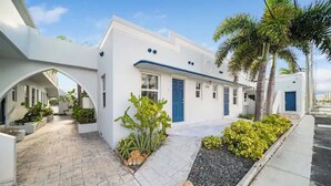 A modern white building with blue doors and a covered walkway. - Waterside Escape w/Queen Bed and Free Parking (Hollywood)