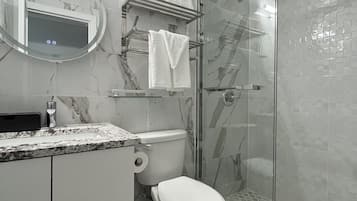 Une salle de bain moderne équipée de toilettes, d’un lavabo et d’une douche.