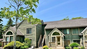 A row of two-story houses with a central entrance and a small porch. - Pool Access | Fireplace, Deck & A/C (Somerset)